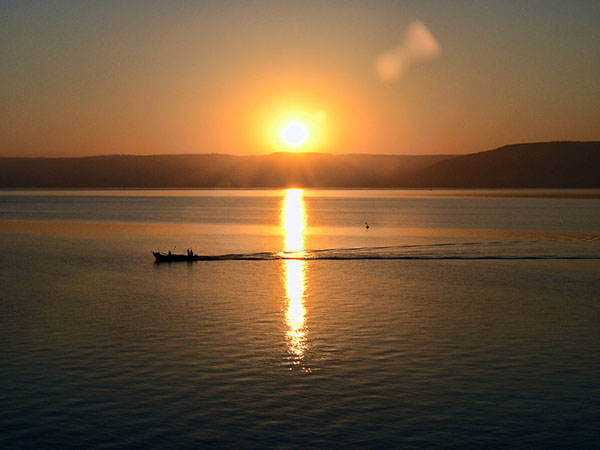Sunrise on the Sea of Galilee as a fisherman comes to harbor. Photo by Ferrell Jenkins 2015.
