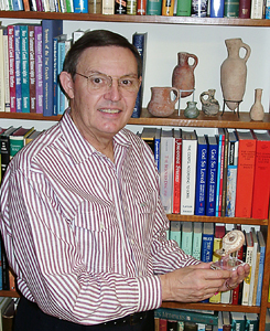 Ferrell Jenkins in his study, holding Herodian lamp.